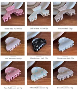 Detail of colorful resin hair claws with heart and bow patterns on wooden background