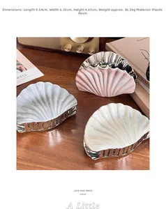 Detail showing shell claw clip dimensions 9.54cm by 6.33cm on a retro wooden table