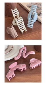 Close-up of assorted claw clips with butterfly and heart patterns in various soft colors