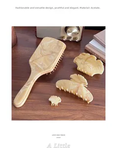 Flat lay of marble texture acetate hair claw clips and large cushion hairbrush set