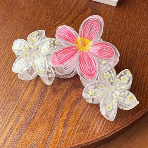 Detail view of large trapezoidal hair claw with peach pink and white acrylic flowers