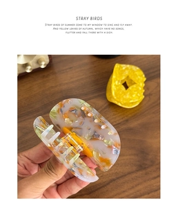 Detailed close-up of premium acetate hair claw clip with colorful marble textures