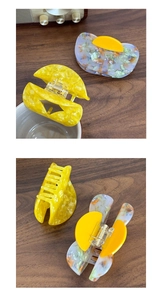 Detailed view of yellow acetate claw clip with marble texture and metal spring structure