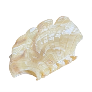 Elegant shell-shaped hair claw clip with beige marble texture and acetate finish