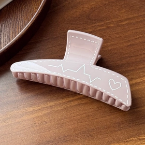Detail of pink Morandi claw clip with white stitch lines and heartbeat heart pattern