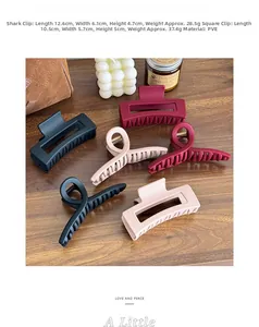 Matte PVE shark and square hair claw clips in black, mauve, and red on a wood surface