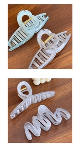 Detailed view of jelly blue and cream hair claws with elegant marble texture and metal spring