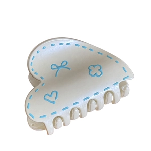 Pearlescent white heart-shaped hair claw clip with blue graffiti ribbon and flower motifs