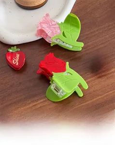 Détail des mini pinces à cheveux rose et fraise avec finition brillante et ressort métallique