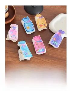 Close-up of creative fish bag hair claws with colorful ocean patterns on wooden surface