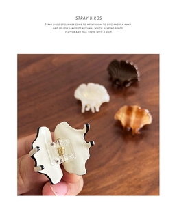 Detail of ginkgo leaf hair clip featuring cream acetate finish and gold metal spring