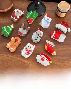 Close-up of glittery acetate Christmas hair clips featuring Santa and reindeer shapes