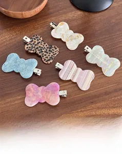 Close-up of six geometric acetate duckbill hair clips with various marble and leopard patterns