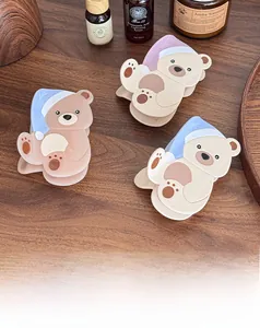 Primo piano di tre graziose mollette per capelli a forma di orso in blu, viola e grigio