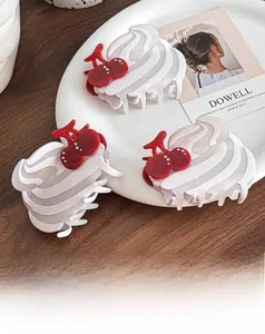 Détail de pinces à cheveux en acétate motif cerise sur une assiette blanche