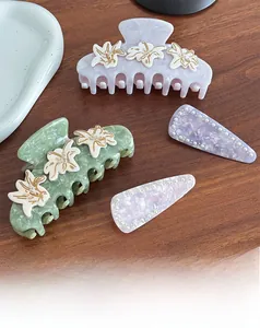 Dettaglio di pinze per capelli in acetato con fiori e forcine di perle su legno