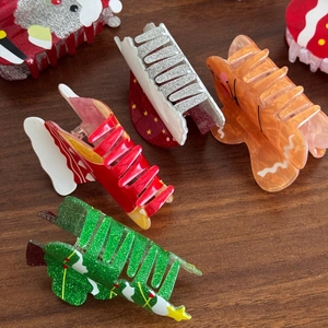 Cute Christmas hair claws featuring Santa, gingerbread man and tree designs on wood