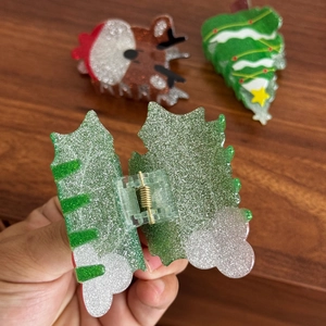 Cute Christmas hair claws featuring reindeer and tree shapes in festive acrylic
