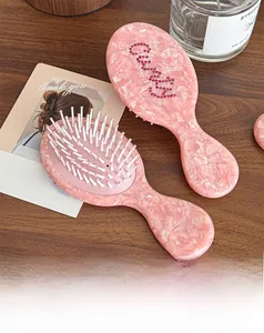 Detail view of pink rhinestone CHANCE lettering on a marble textured acetate hairbrush