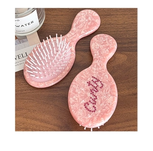 Macro detail of pink marble acetate hairbrush with sparkling rhinestone decorations