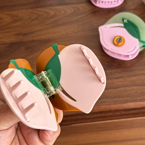 Pince à cheveux en acétate en forme de pêche avec dégradé rose et détail de feuille verte