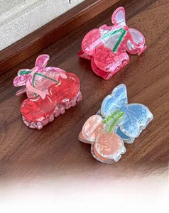 Detail of sweet cherry hair claw clips in colorful acetate on a rustic wooden surface