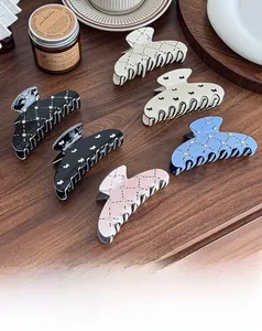 Detail showing various puppy hair claws with rhinestones on a warm wooden tabletop