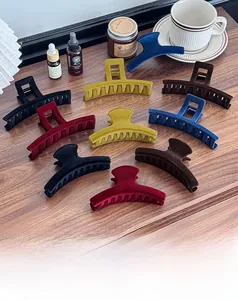 Macro shot of assorted flocking hair claws in vintage colors on a wooden table surface