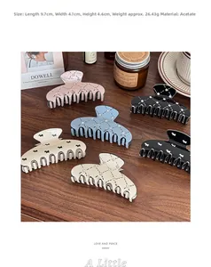 Detailed size view of the engraved puppy hair claw clip on a warm wooden surface