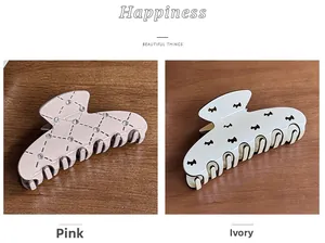 Detail view of pink rhinestone lattice and cream puppy pattern hair claws on wood