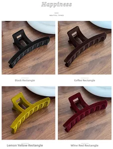Detail showing four colors of large flocked hair clips on a wooden surface with a macro view