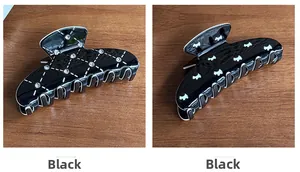 Detail of black hair claw clips featuring white puppy silhouette and diamond grid pattern
