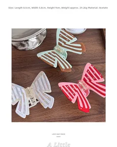 Close-up of three acetate butterfly hair claws in mint, pink, and purple striped patterns
