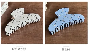 Detailed view of cream and blue hair claws with diamond lattice pattern and rhinestones