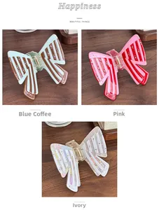 Detail of butterfly hair claws with striped patterns and rhinestone accents in three colors