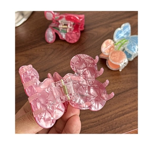 Detail of cherry hair claw clip with marble texture and transparent spring mechanism