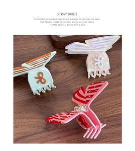 Detailed view of three butterfly hair claws in two-tone acetate with a polished finish