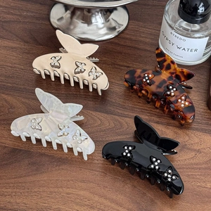 Set di quattro mollette per capelli a farfalla in acetato con strass su legno scuro