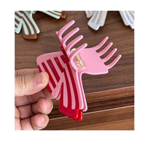 Detail shot of striped butterfly hair claw clip featuring pink and dark red wavy patterns