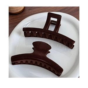 Detailed view of large brown flocked shark hair clips with a soft velvet texture finish