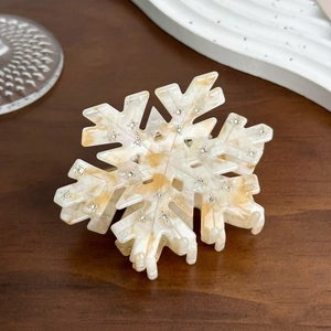 Detail of snowflake hair claw in cream acetate with marble texture and small crystals
