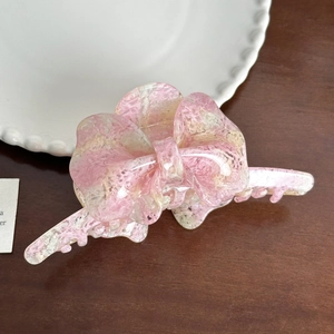 Pink and white marble texture butterfly hair claw clip on a rustic wooden background