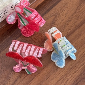 Cute cherry and floral acrylic shark hair clips with marble texture on wood surface