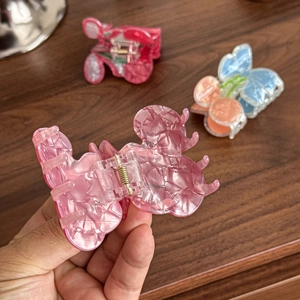 Pink butterfly hair claw clip with translucent stone texture and spring closure mechanism