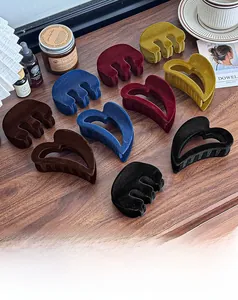 Détail de pinces à cheveux floquées en formes de cœur et de vagues sur une table en bois