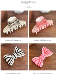 Detail view of bow hair claws with striped patterns in cream and peach resin finish