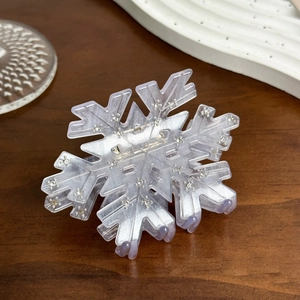Macro view of snowflake hair claw clip with glitter finish and shimmering rhinestones