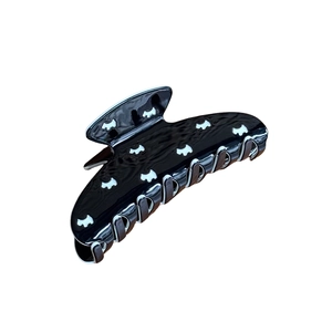 Elegant large black hair claw clip with white puppy motif in polished finish