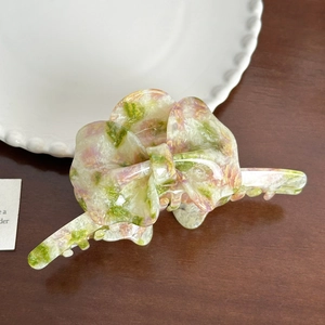 Close-up of pink and green marbled butterfly hair claw clip with acetate texture details