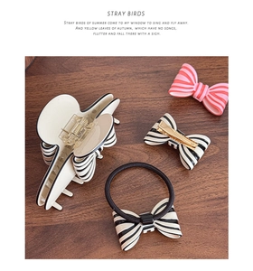 Flat lay of vintage French bow hair clips and scrunchie on dark wooden background